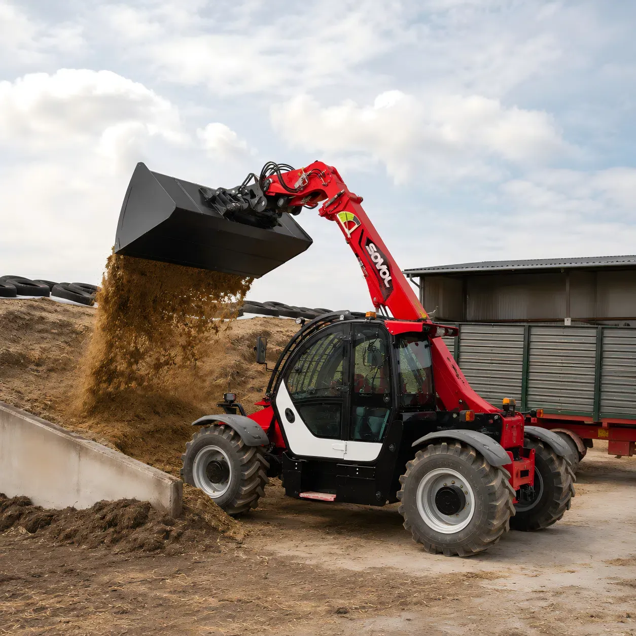 SOVOL SW735 3.5 ton telehandler, bir çiftlik avlusunda kepçeyle tarımsal malzeme boşaltıyor