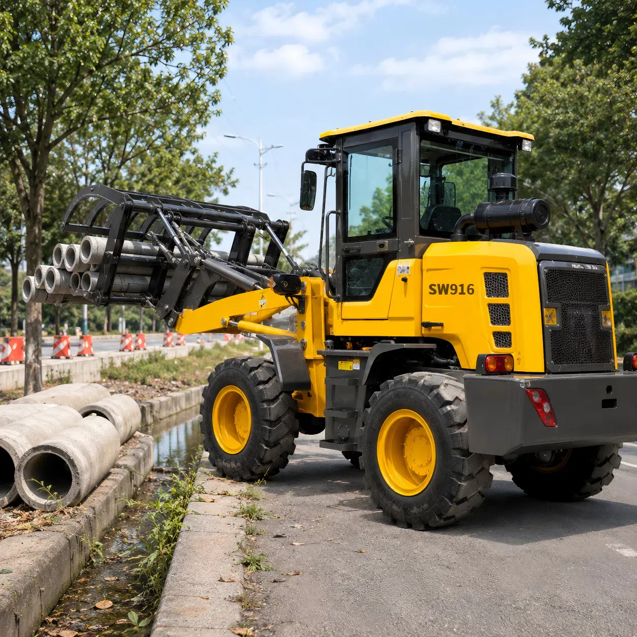 SOVOL SW916 tekerlekli yükleyici, boru kavrayıcı ile donatılmış, yol onarımı ve altyapı bakım çalışmaları için beton drenaj borularını taşıyor.