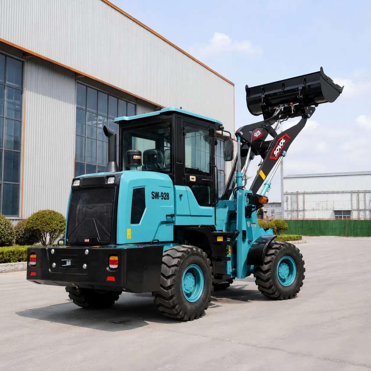 SOVOL SW928 1.2 ton kompakt tekerlekli yükleyicinin yükseltilmiş kepçe ile arka yan görünümü, endüstriyel alanlar, çiftlikler ve hafif inşaat malzemesi taşıma için uygundur.